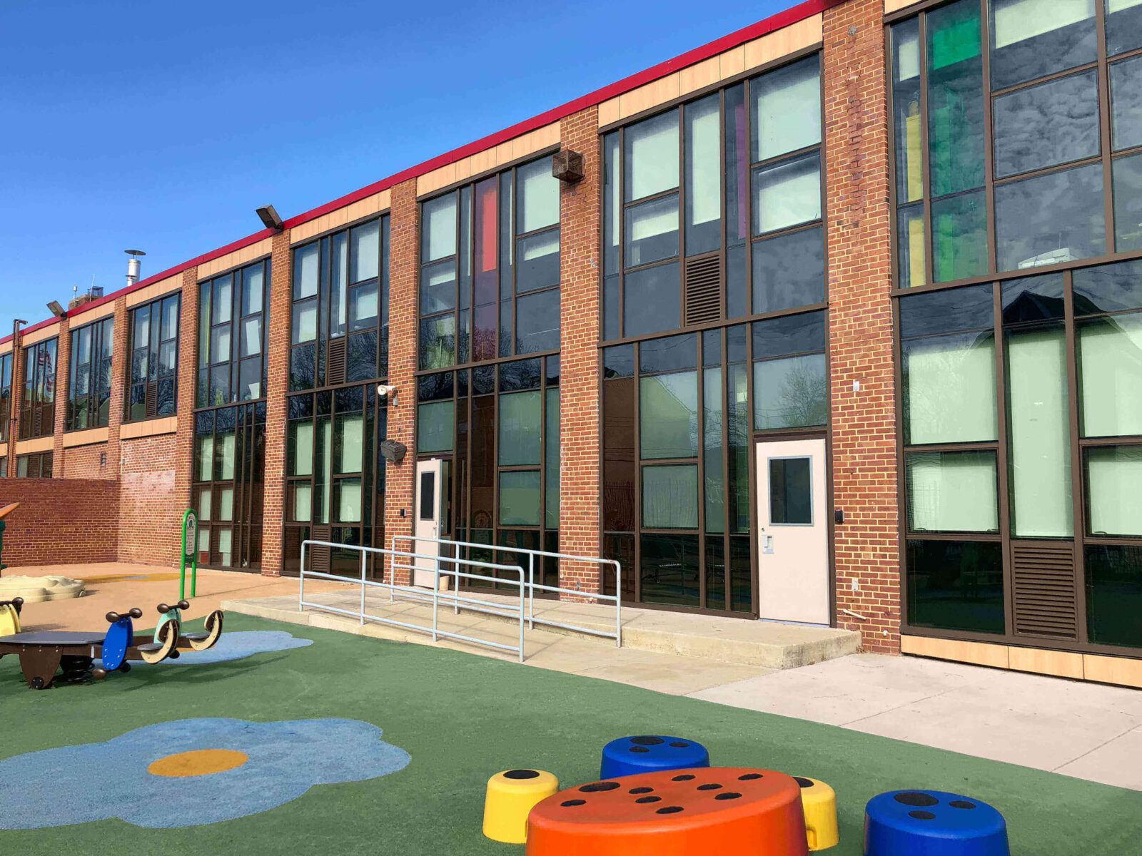 School building with colorful playground equipment.